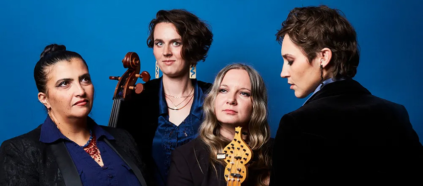Four people standing holding musical instruments