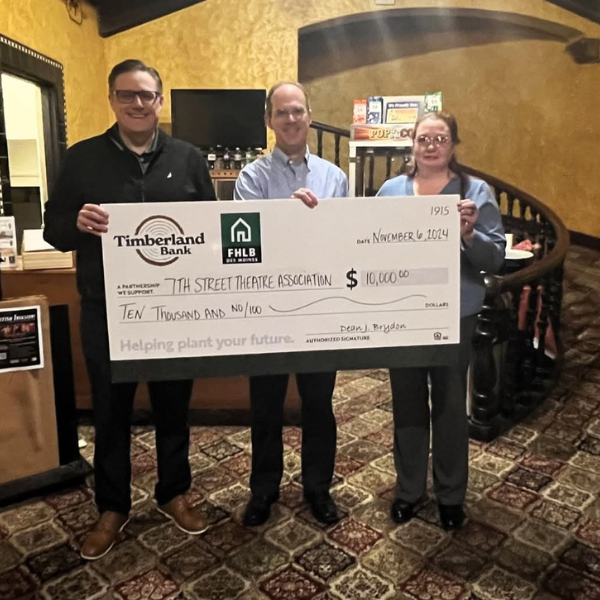 Meredith holds a giant 10,000 dollar check granted for the 7th Street Theater Association, next to two men I was not given the names of. 
