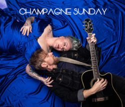 two people laying in blue blankets with one holding a guitar and the words champagne sunday above